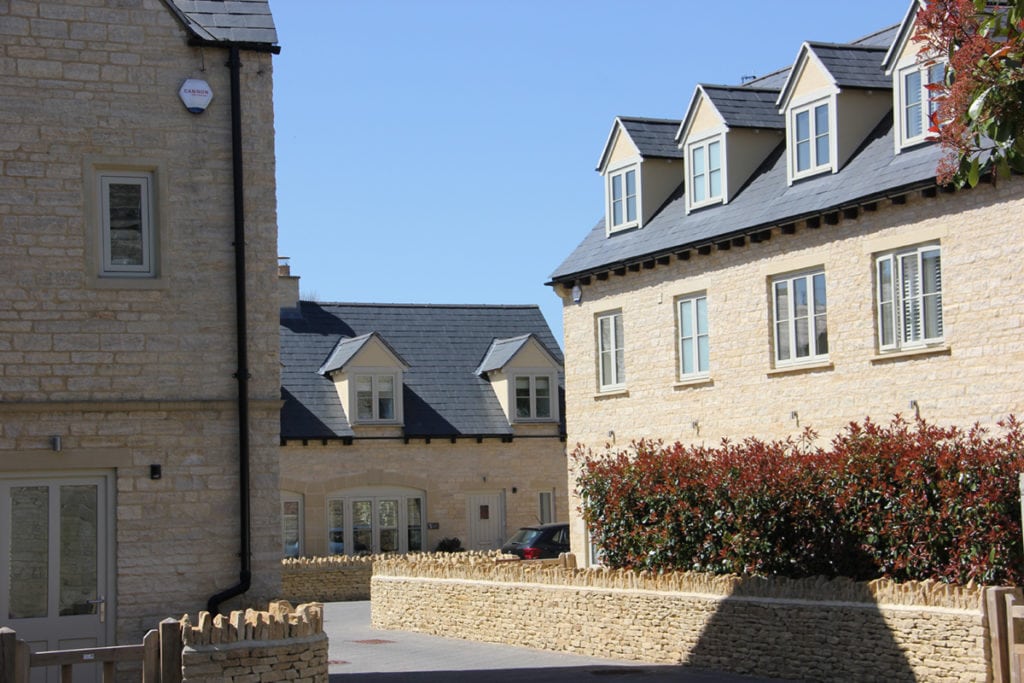 Cirencester developer housing historic context Cotswold stone dormer window slate roof dry stone wall